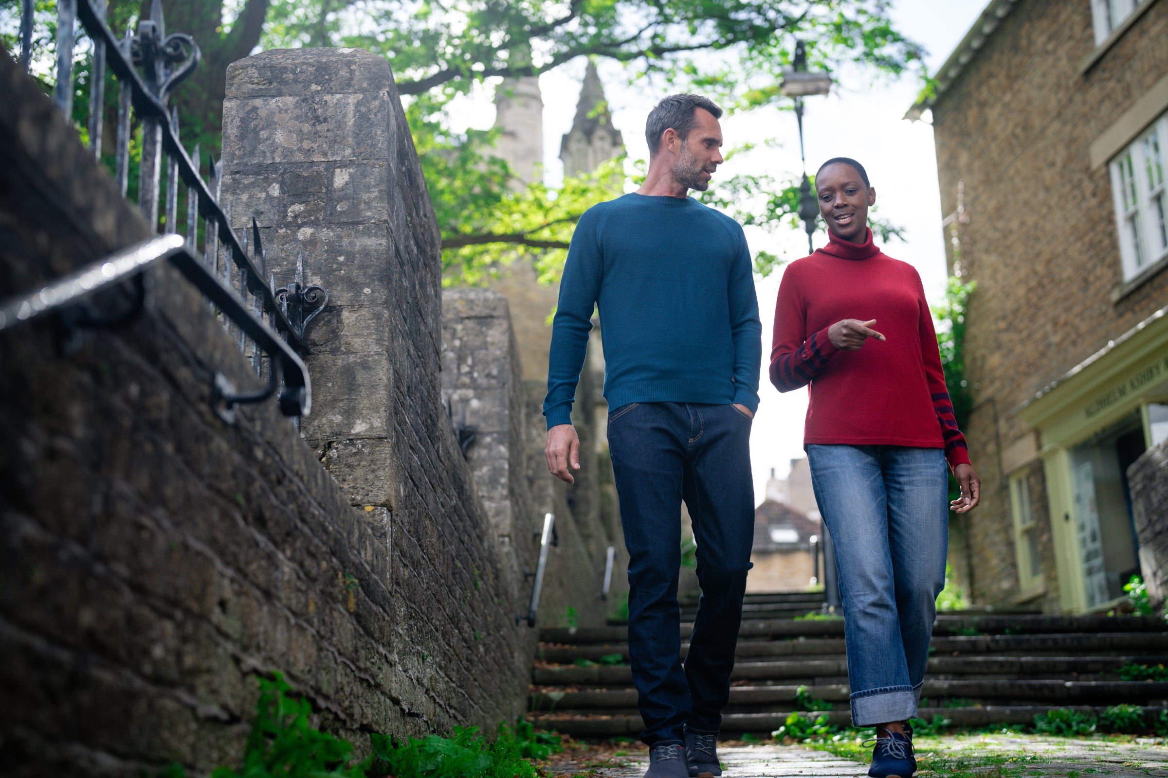 A man and a woman walking down a stone pathway, casually chatting